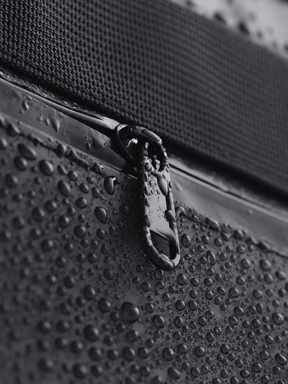 Water droplets on the water-resistant fabric and zipper of a CISTA tote.